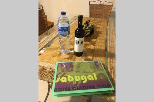 una botella de vino y un libro sobre una mesa en A Casinha rústica com todo o conforto en Aldeia da Ponte