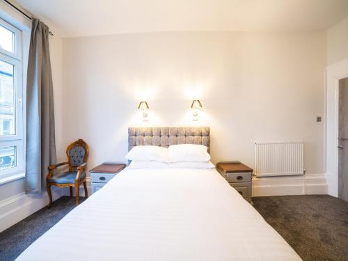 a bedroom with a large white bed and a window at Churchill's Hotel in Wombwell