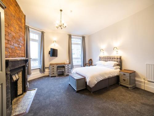 1 dormitorio con 1 cama y chimenea en Churchill's Hotel, en Wombwell