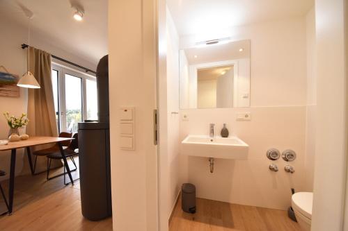 ein Badezimmer mit einem Waschbecken, einem WC und einem Tisch in der Unterkunft SPA Penthouse Meerlust in Baabe