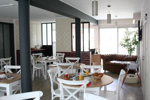 un restaurante con mesas y sillas y un sofá en Hôtel Le Relais Dax, en Dax