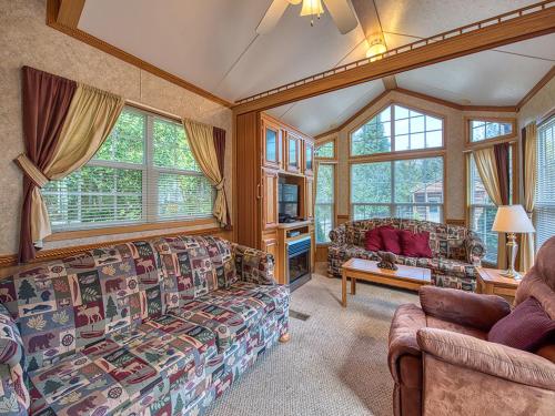 a living room with a couch and some windows at Maggie Valley Cabin Rentals in Maggie Valley