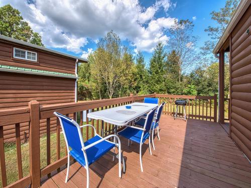 a patio with a table and chairs on a deck at Maggie Valley Cabin Rentals in Maggie Valley