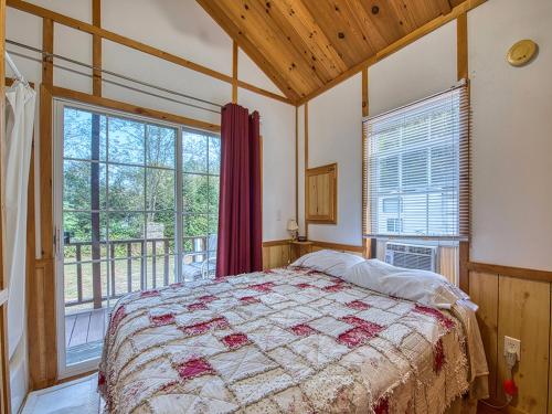 a bedroom with a bed and a large window at Maggie Valley Cabin Rentals in Maggie Valley