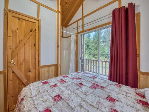 a bedroom with a bed and a large window at Maggie Valley Cabin Rentals in Maggie Valley