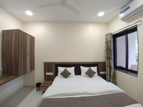 a bedroom with a large bed with a window at Hotel Matruchhaya - Near Lonavala Market Railway and Bus Station in Lonavala