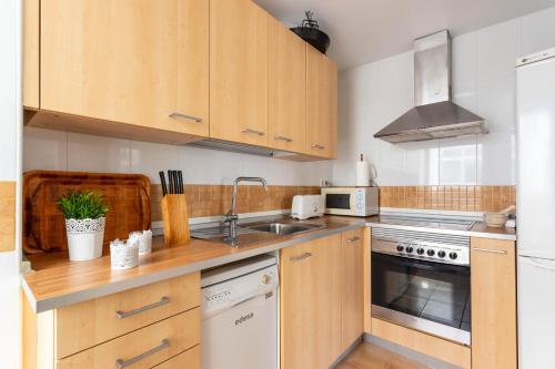 a kitchen with wooden cabinets and a sink at Dúplex Algarrobo Costa in Algarrobo