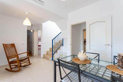 a living room with a glass table and a chair at Dúplex Algarrobo Costa in Algarrobo