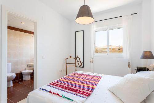 a white bedroom with a bed and a bathroom at Dúplex Algarrobo Costa in Algarrobo