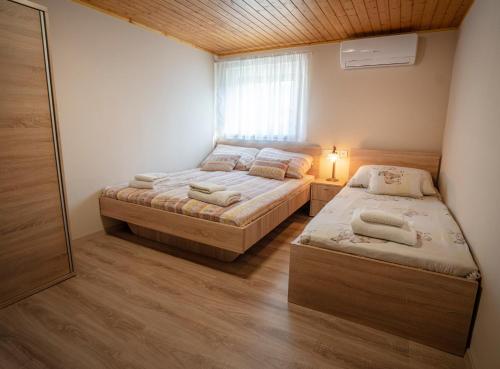 1 dormitorio con 2 camas y ventana en Anna-Lak, en Dunapataj
