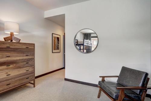 a room with a chair and a mirror on a wall at The Arrabelle at Vail Square, a RockResort in Vail
