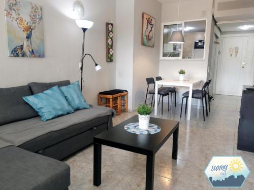 ein Wohnzimmer mit einem Sofa und einem Tisch in der Unterkunft Sunny Torremolinos Centro in Torremolinos
