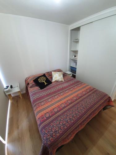 a small bedroom with a bed in a room at Departamento en Lomas de Papudo V in Papudo