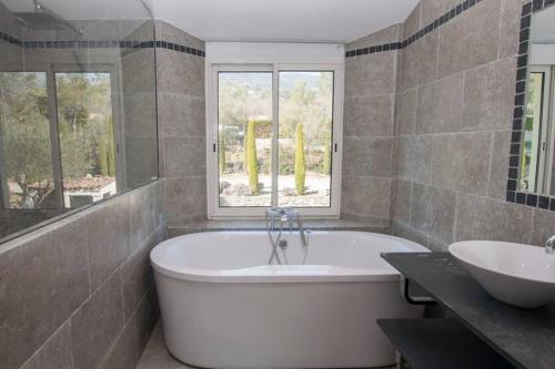 トゥレット・シュル・ルーにあるLa Lavandeの大きな浴槽と洗面台のあるバスルーム