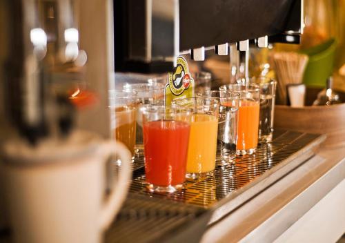 a row of glasses filled with different colored drinks at NunoHotel in Cologne
