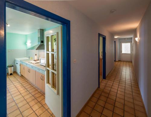 une cuisine avec une porte s'ouvrant sur un couloir dans l'établissement Meublé Le Coin Tranquille, à Saverne