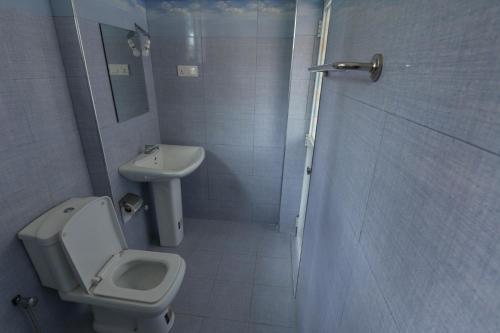 a bathroom with a toilet and a sink at Mallika Resort in Mirissa