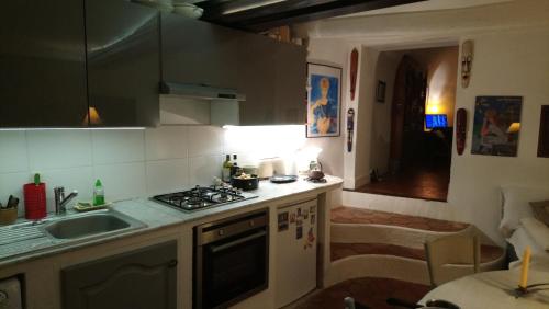 una cocina con fregadero y estufa horno superior en Dans village médiéval piétonnier, Suite exécutive vue mer exceptionnelle, en Roquebrune-Cap-Martin