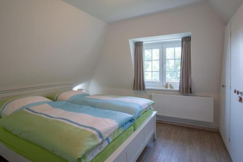 een slaapkamer met 2 bedden en een raam bij Dat Slott in Pellworm