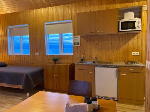 eine kleine Küche mit einem Bett und einer Mikrowelle in der Unterkunft Beindalsholt in Hella