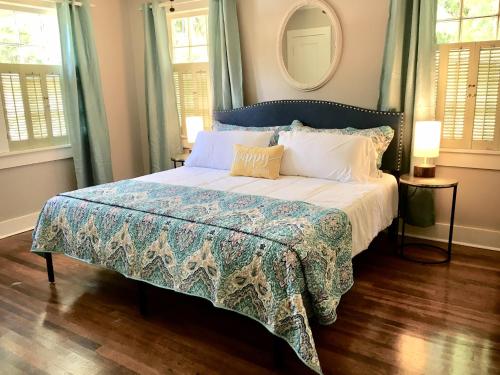 a bedroom with a bed with a blue and white bedspread at KING BED Family Friendly Cottage - Walk to Zoo & Waterpark - Near Downtown & Midtown in Hattiesburg
