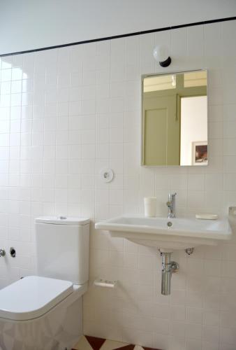a bathroom with a toilet and a sink and a mirror at São Gião House 4 in Tomar