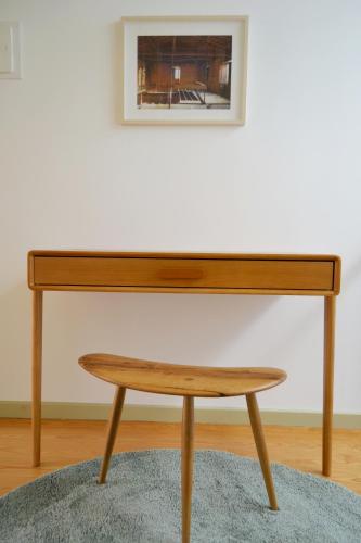 a wooden piano with a wooden stool in front of a wall at São Gião House 4 in Tomar