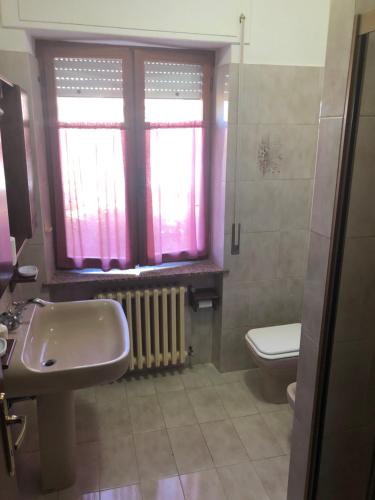 baño con lavabo y aseo y ventana en La Tana della Volpe B.&.B., en Montecassiano