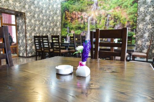 a table with a vase with flowers and candles on it at Zangezur Hotel in Goris