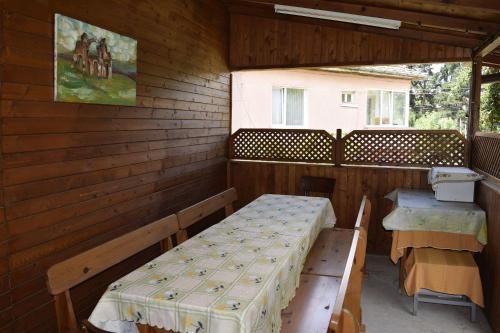 a porch with two benches and a table in it at Стаи за гости "Нина" in Velingrad