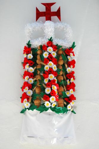 a white vase filled with flowers and a cross at São Gião House 4 in Tomar