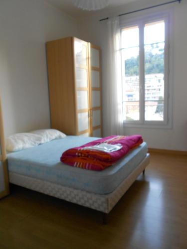 a bed in a room with a large window at Beau 3 pieces proche centre in Menton