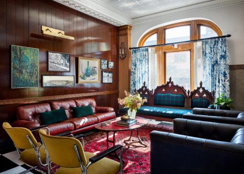 a living room with leather furniture and a table at Graduate by Hilton New Haven in New Haven