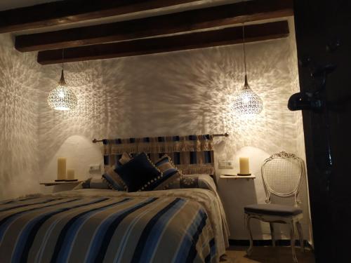 1 dormitorio con 1 cama y 2 luces colgantes en El escondite de Martina, Casa Rural Romántica, en Setenil