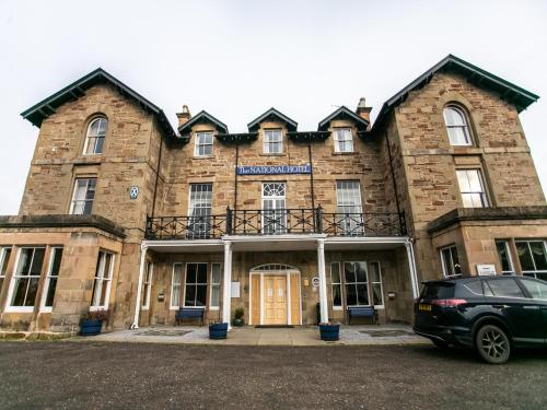 a building with a car parked in front of it at The National Hotel in Dingwall