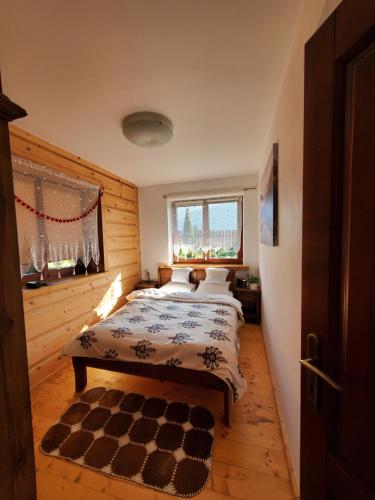 コシチェリスコにあるApartament z widokiem na Giewontのチェッカー付きの敷物が備わるベッドルーム1室が備わります。