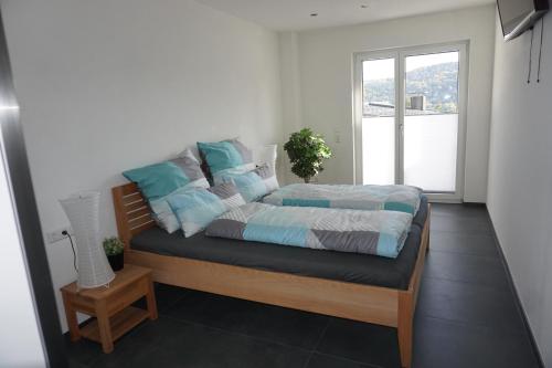 a bedroom with a bed with blue and white pillows at Ferienwohnung Schauinsland in Neuenbürg