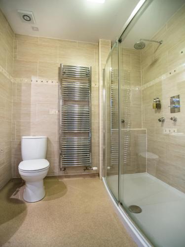 a bathroom with a toilet and a glass shower at The National Hotel in Dingwall