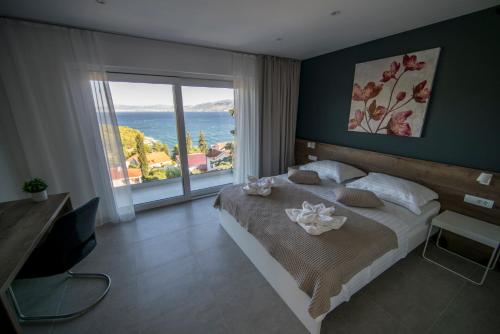 a bedroom with a large bed and a large window at Villa D in Postira