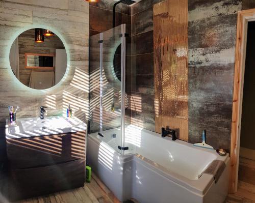 a bathroom with a tub and a sink and a mirror at Cottage Grove Homestay rooms in Portsmouth