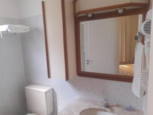 ein Badezimmer mit einem Waschbecken, einem Spiegel und einem WC in der Unterkunft Apartment on Oscar Freire by Paulista and Clínicas in São Paulo
