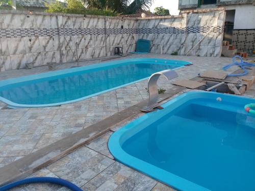 a pair of swimming pools in a backyard at Casa para temporada in Tamoios