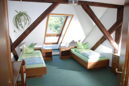 a attic room with two beds and a window at Gasthof und Pension Frankenthal - garni in Gera