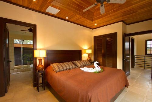 a bedroom with a large bed with a swan on it at Jet Luxury at Langosta Beach Resort & Villas in Tamarindo
