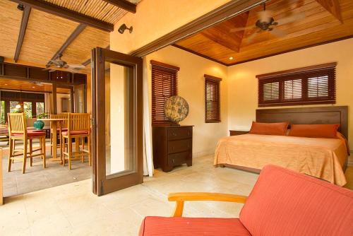 a bedroom with a bed and a table and chairs at Jet Luxury at Langosta Beach Resort & Villas in Tamarindo