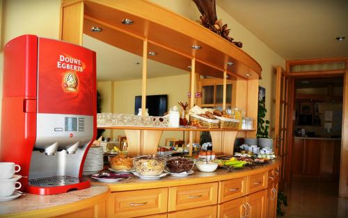 a kitchen with a red refrigerator on a counter at Hotel Weldi in Győr