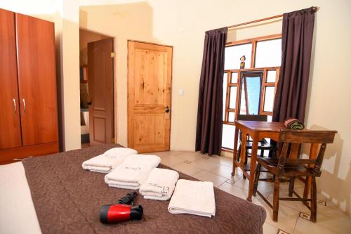 Habitación con escritorio y mesa con toallas. en Hostal y Cabañas Renta House San Pedro, en San Pedro de Atacama