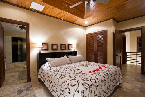 a bedroom with a bed with red roses on it at Jet Luxury at Langosta Beach Resort & Villas in Tamarindo