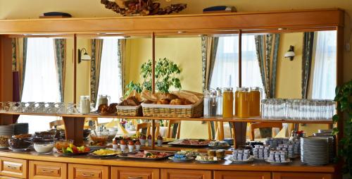 a buffet with a lot of food on a table at Hotel Weldi in Győr