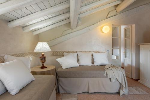 a bedroom with two beds and a table with a lamp at Hotel Palazzo Novello in Montichiari